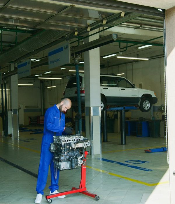 Expert male mechanic working with professional automotive diagnostic computer equipment